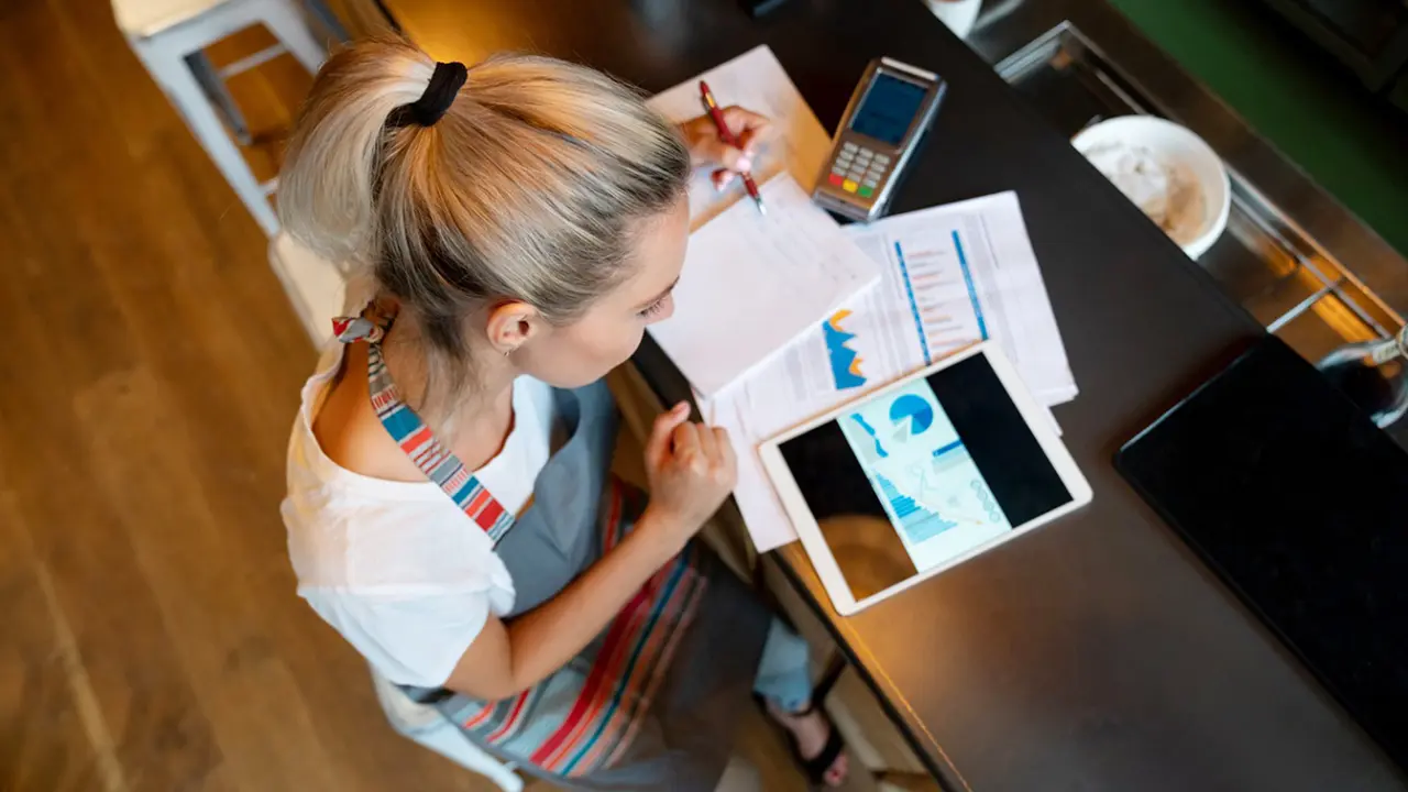 Portrait of a business manager doing the books at a bar using a tablet computer