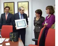 El ministro consejero, el cónsul general y la secretaria xeral de Sanidade observan el momento en el que el presidente de la FES recibe un presente de la conselleira María José Rubio.