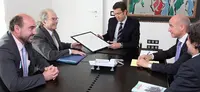 Esquivel hace entrega del dibujo a Feijóo en presencia de Luis Vaamonde, director de ‘Galicia en el Mundo’.