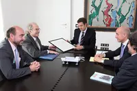 Esquivel hace entrega del dibujo a Feijóo en presencia de Luis Vaamonde, director de ‘Galicia en el Mundo’.