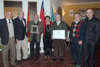  Ramos posa con el grupo de socios nacidos en Asturias, con el Reconocimiento y la placa con la cruz de la victoria.