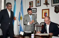  Camba -acompa&ntilde;ado de Santos Gast&oacute;n y Alejandro L&oacute;pez- lee la dedicatoria que dej&oacute; en el libro de visitantes. 