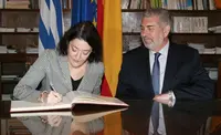  Anna Terr&oacute;n firma, en presencia de Manuel Barros, el libro de la C&aacute;mara de Comercio.