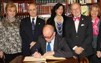 Camba firma en el Libro de Honor del Centro Gallego de Santander, junto a directivos.