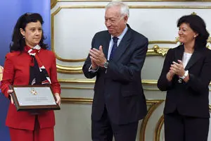 GRA238. MADRID, 22/12/2014.- El ministro de Exteriores, José Manuel García-Margallo (c), y su esposa María Isabel Barreiro Fernández (d), aplauden a la presidenta de la Asociación de Familias de Diplomáticos (AFD), Adriana de la Riva (i), tras entregarle la placa de la Orden del Mérito Civil en un acto en el Palacio de Viana.- EFE/Juan Carlos Hidalgo