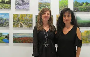 Las pintoras Pilar Quintás y Esperanza Martínez de Salinas ante algunos de los cuadros que exponen en la Casa de Galicia