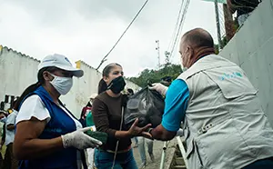 UNICEF staff gives a woman the food kit delivered by UNICEF on the outskirts of Caracas, Venezuela on April 29, 2020.

The deteriorating situation inside Venezuela puts children at risk of dropout school. Since 2019, UNICEF started a pilot program to support school feeding program in prioritized educational centers to prevent the drop out school. In order to keep the access to school feeding service during quarantine due to COVID-19, UNICEF has provided food kits to the students family instead.

