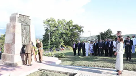 Sus Majestades los Reyes durante la colocación de una corona a los pies del monumento al soldado español  