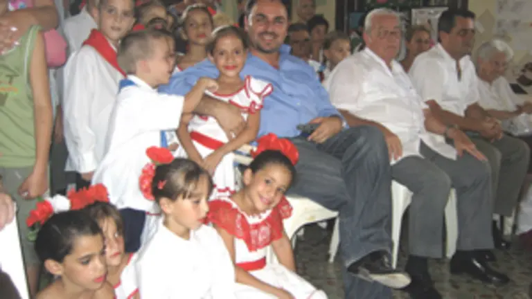  Moisés Plasencia rodeado de niños con el traje típico en su reciente visita a Cuba.