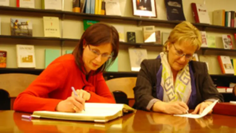 Carme Ad&aacute;n (I) firma en el Libro de Visitas de la Oficina de la Xunta en Buenos Aires, en presencia de Mar&iacute;a Xos&eacute; Porteiro 