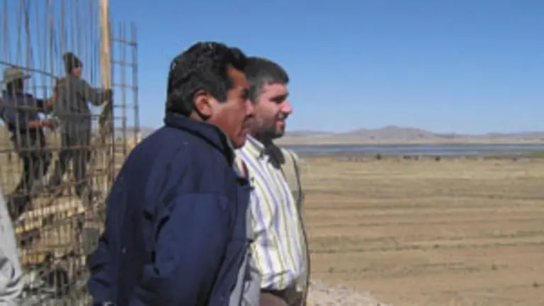  Eugenio Rojas y Jacinto Bra&ntilde;as -detr&aacute;s-, junto a las obras del dep&oacute;sito en construcci&oacute;n en el lago Titicaca.