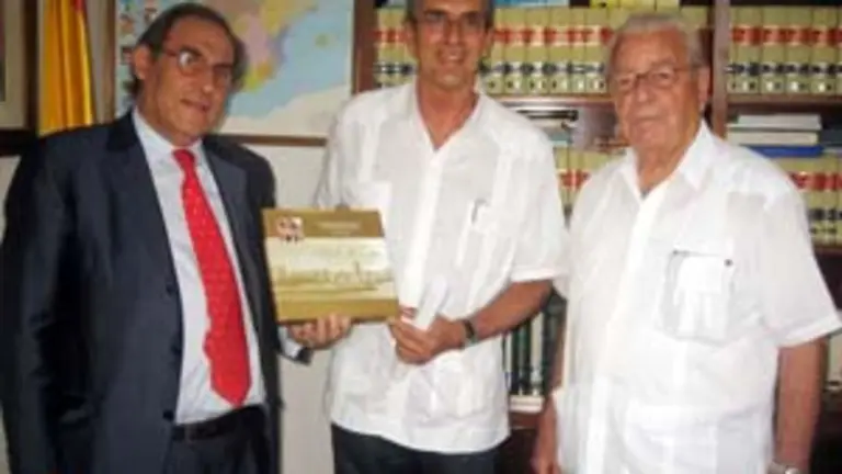  Pablo Barrios muestra a Machín el ‘Libro de Oro’ del Hogar Canario de Cuba, en presencia de Carmelo González.