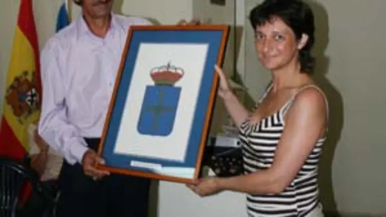  Eugenia &Aacute;lvarez entrega un cuadro con el escudo de Asturias a V&iacute;ctor Valle.
