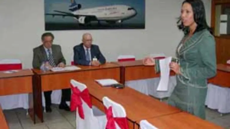  Antonio Álamo Lima y Antonio Jiménez Rodríguez escuchan la intervención de la gerente comercial de Santa Bárbara Airlines, Aura Parra.