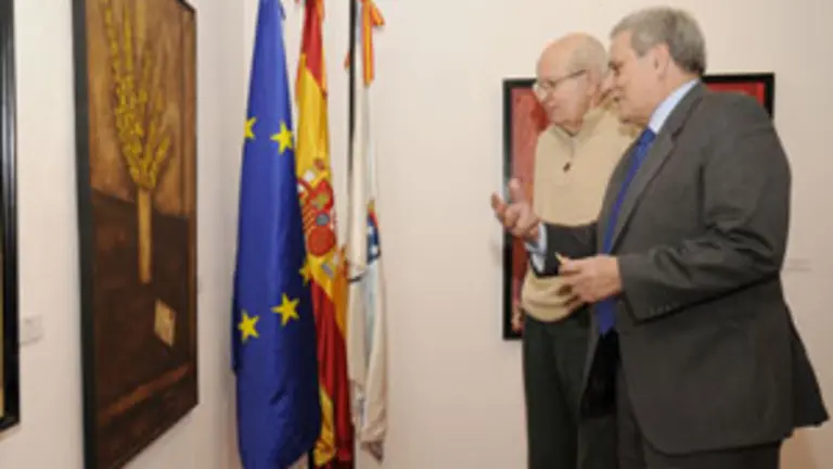  Alfonso S. Palomares contempla, junto a Virxilio, uno de los cuadros de la colecci&oacute;n del artista gallego.