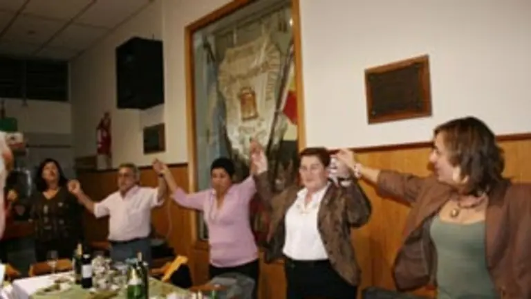 Ordiz y Serrano cantan el himno de Asturias junto a directivos y socios del Centro Cangas del Narcea.