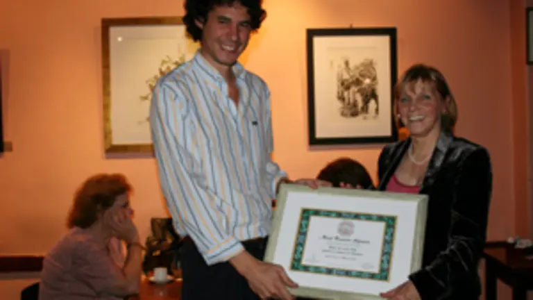  Graciela Pereira le entrega un diploma enmarcado a Ra&uacute;l Alfons&iacute;n, nieto.