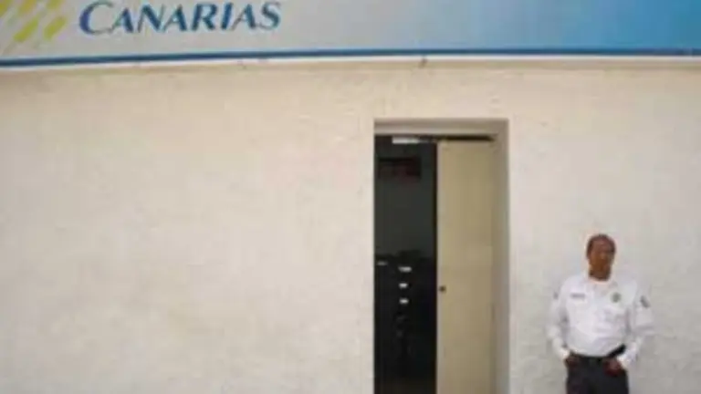  Un guardia privado custodia la entrada de la agencia del Banco Canarias que funciona dentro del HCV.
