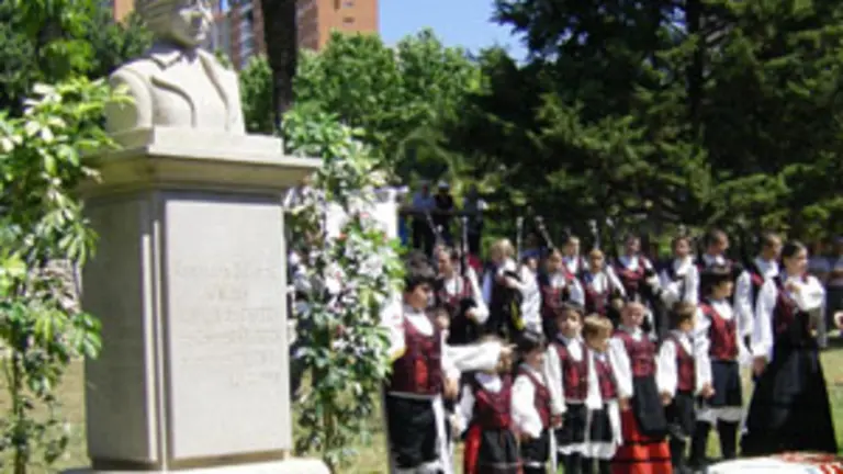  Mozos dun grupo folcl&oacute;rico posan xunto ao busto de Rosal&iacute;a de Castro trala ofrenda floral.
