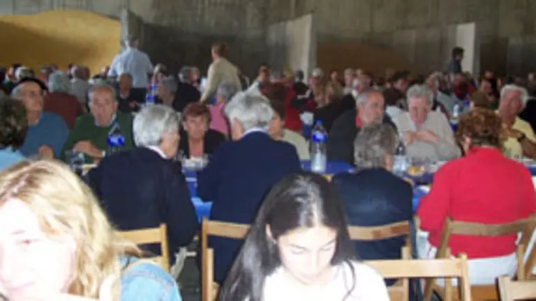 La lluvia provocó que la comida de hermandad tuviera que celebrarse en una nave agrícola.