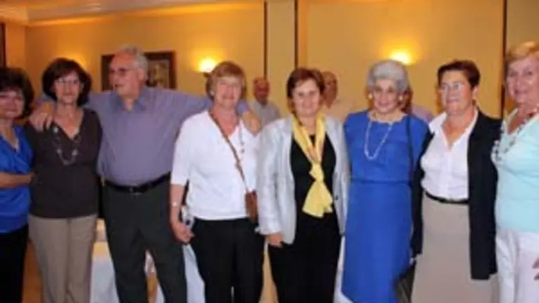 Mar&iacute;a Jos&eacute; Ramos y Teresa Ordiz posan con algunos de los emigrantes durante el acto de despedida. 