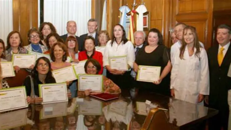  Pilar Farjas, Santiago Camba y Alfonso Rueda posan con los diplomados en auxiliar de enfermer&iacute;a.