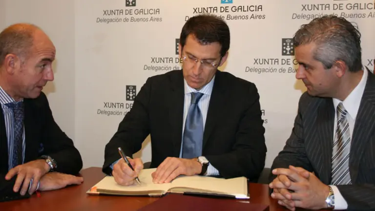 El presidente Feij&oacute;o, -en el centro- firma en el Libro de Oro de la Delegaci&oacute;n.