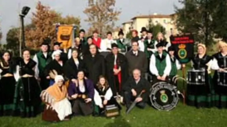 La banda de gaitas Ciudad Cangas de On&iacute;s posa junto a dirigentes del Centro. 