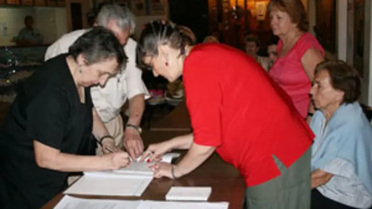 En la mesa de entrada, verificando que los delegados cumplan con los requisitos del estatuto de la instituci&oacute;n. 