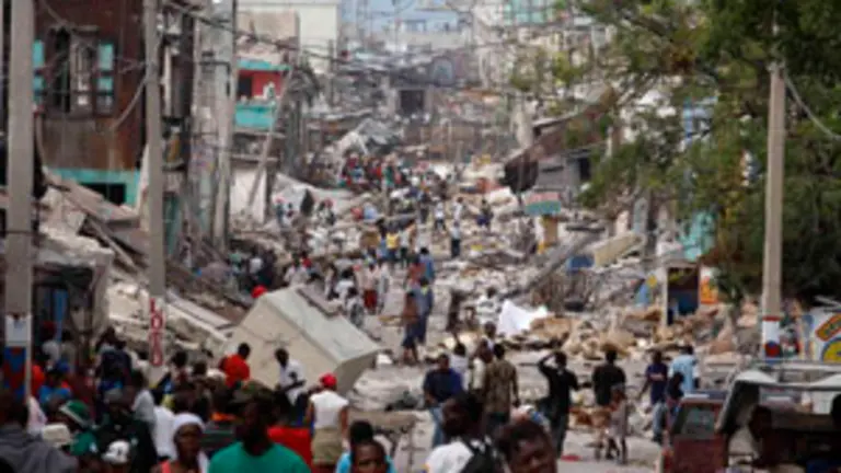  Habitantes de Puerto Pr&iacute;ncipe caminan por una de las zonas destruidas de la capital haitiana.