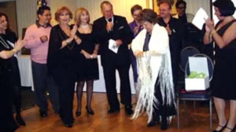  La presidenta, Charo Monge, se prueba el mant&oacute;n de seda que le regalaron.