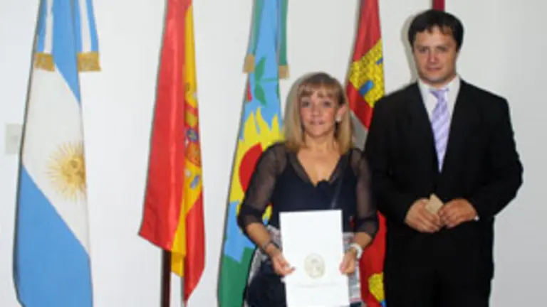 Isabel Carrasco, junto al director de Colectividades, con la declaración de \'Huésped de Honor\'.