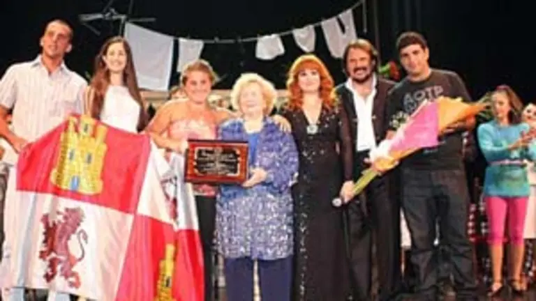  María Engracia, acompañada por sus hijos, recibe una placa de homenaje.