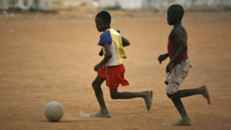  Dos ni&ntilde;os africanos juegan al f&uacute;tbol.