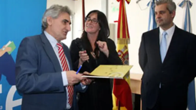 Francisco L&oacute;pez lee, asistido por Alejandra Ram&iacute;rez, la dedicatoria que escribi&oacute; en su libro para la biblioteca. A su lado el delegado del gobierno gallego en Argentina, Alejandro L&oacute;pez.