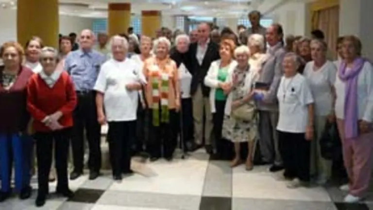  El secretario xeral de Emigraci&oacute;n y directivos de la HGV posan con los mayores que acuden al centro de d&iacute;a.