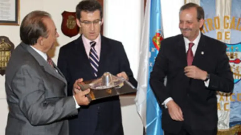  Feij&oacute;o recibe un regalo del presidente del Centro Gallego de M&eacute;xico, Luis Pi&ntilde;eiro, en presencia de Antonio Cort&eacute;s.