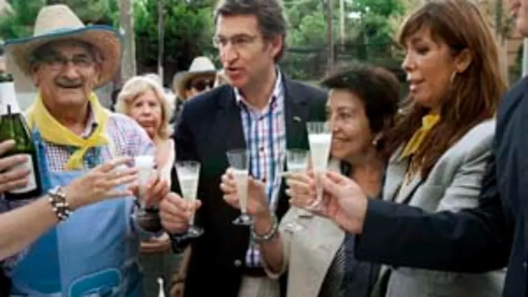  Feijoo y Alicia S&aacute;nchez-Camacho brindan durante el concurso de paellas celebrado en el barrio barcelon&eacute;s de Sarri&agrave;.