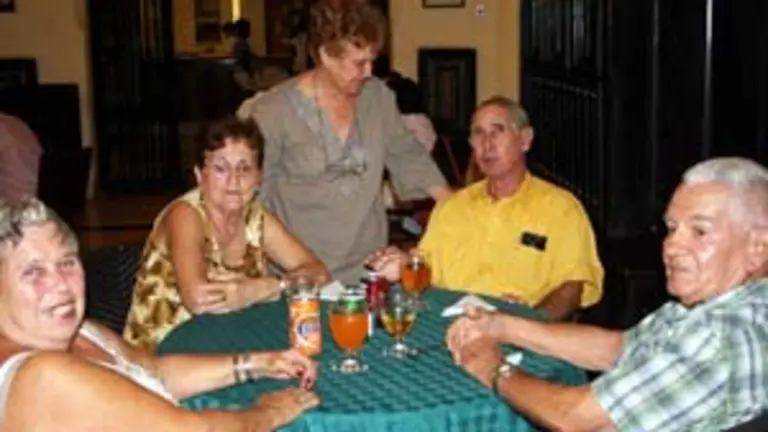  Elena Llimó, presidenta en funciones –de pie–, junto a varios emigrantes.