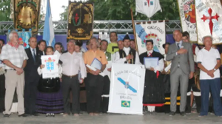 Santiago Camba, escucha el himno gallego, junto a algunos de los representantes de los grupos folcl&oacute;ricos que subieron al escenario en el D&iacute;a de la Galicia Exterior.