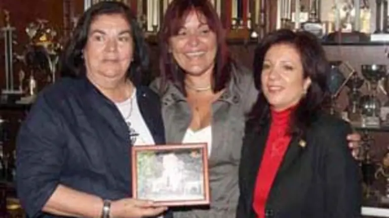  Guillermina Hernández Martín, recibe una fotografía conmemorativa del HCV, de manos de la otrora presidenta de la entidad, Arcilia Díaz González, en compañía de la directora general de la Ciudadanía Española en el Exterior, Pilar Pin Vega, 