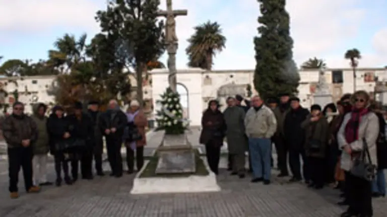 Los asistentes, junto a la ofrenda floral en el cruceiro. 