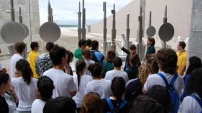 Los j&oacute;venes atienden a las explicaciones de una monitora sobre la Cidade da Cultura. 