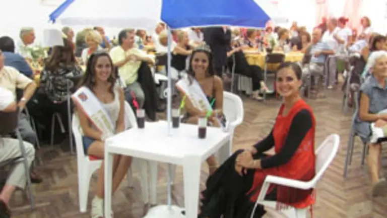  Reina y princesas, exhibiendo uno de los premios del sorteo.