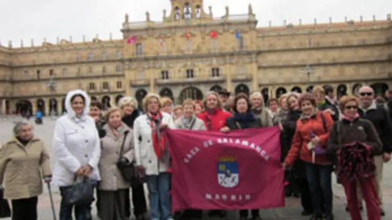 Un grupo de los socios de la entidad posa con la bandera en la Plaza Mayor de Salamanca. 