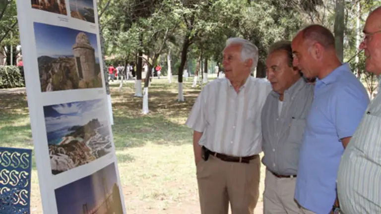 Santiago Camba, acompa&ntilde;ado por Luis Pi&ntilde;eiro y otros asistentes a la romer&iacute;a, ven la exposici&oacute;n fotogr&aacute;fica sobre Galicia.