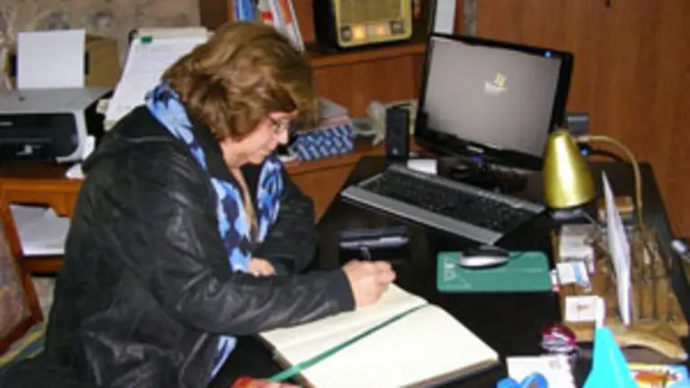 Aurora Mu&ntilde;iz firma en el libro de honor de la asociaci&oacute;n &lsquo;Langreanos en el Mundo&rsquo;. 