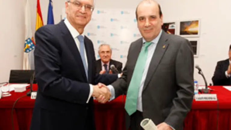 Lema Devesa saluda al homenajeado tras entregarle el diploma que acompaña a la Insignia de Oro de Iurisgama