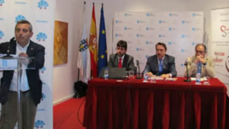 Masaguer, presentando la Jornada, y, en la mesa, los ponentes Sainz, Alonso y Gil