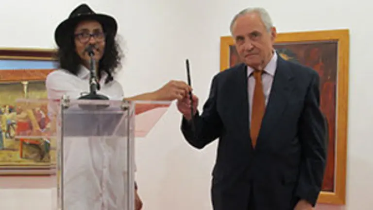 Carlos Santos pasa a José Ramón Ónega el pincel que usó en un gesto en memoria del desastre cultural ocurrido en Brasil